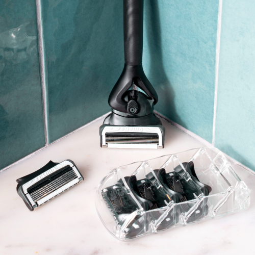 a razor with extra blades, on a shower shelf